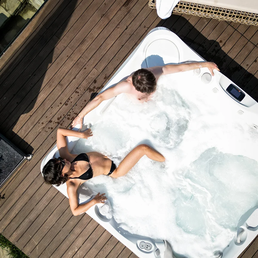 Overhead view of a couple relaxing in an Eden Hill terrace hot tub.