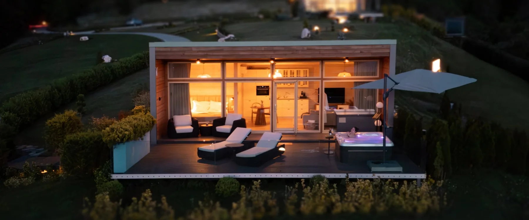 Aerial view of an illuminated Eden Hill villa and its furnished terrace at dusk.