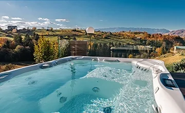 Hot tub on an Eden Hill terrace overlooking autumn-coloured hills beneath a clear sky.