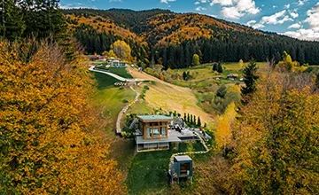 Vedere aeriană a vilelor Eden Hill, între gazon verde și copaci în culorile toamnei.