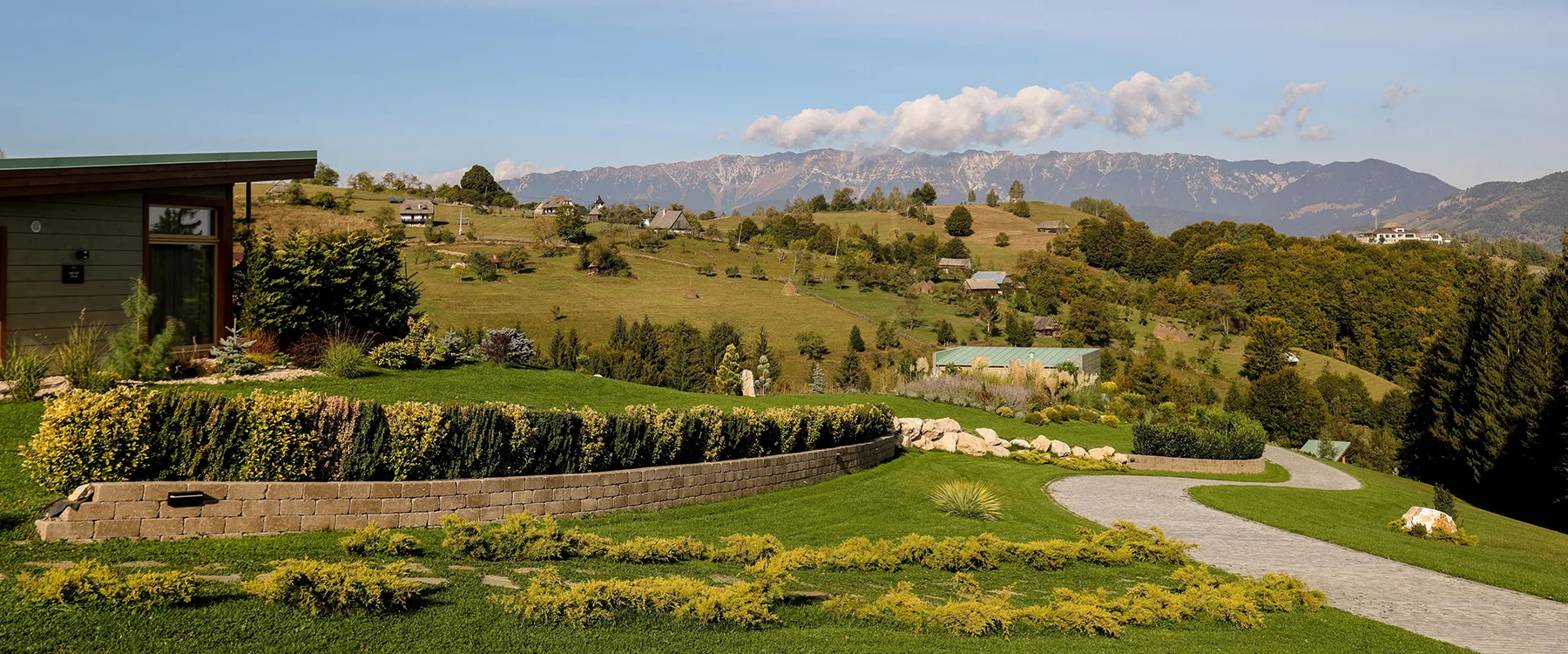 Stone path through the Eden Hill garden beside a villa, with mountains on the horizon.