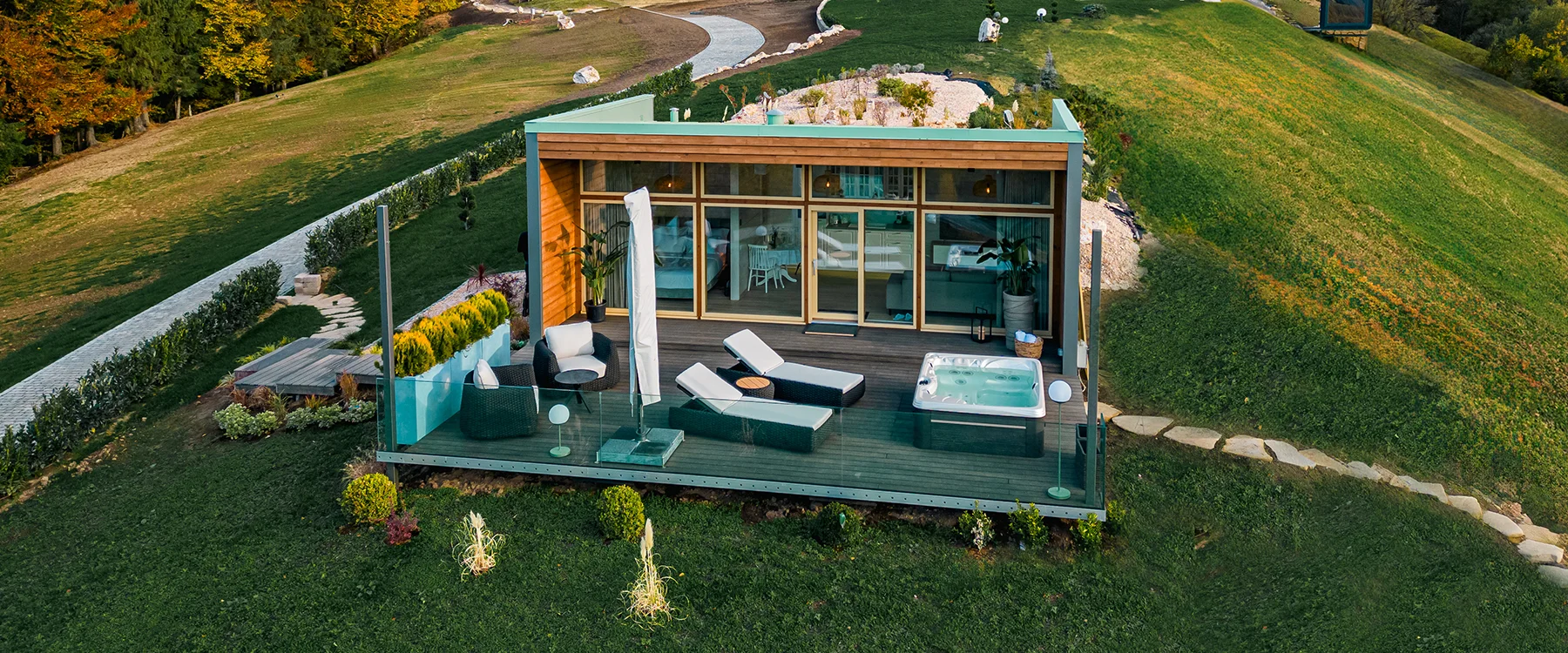 Elevated view of a glass-fronted Eden Hill villa, its furnished terrace and lawn.
